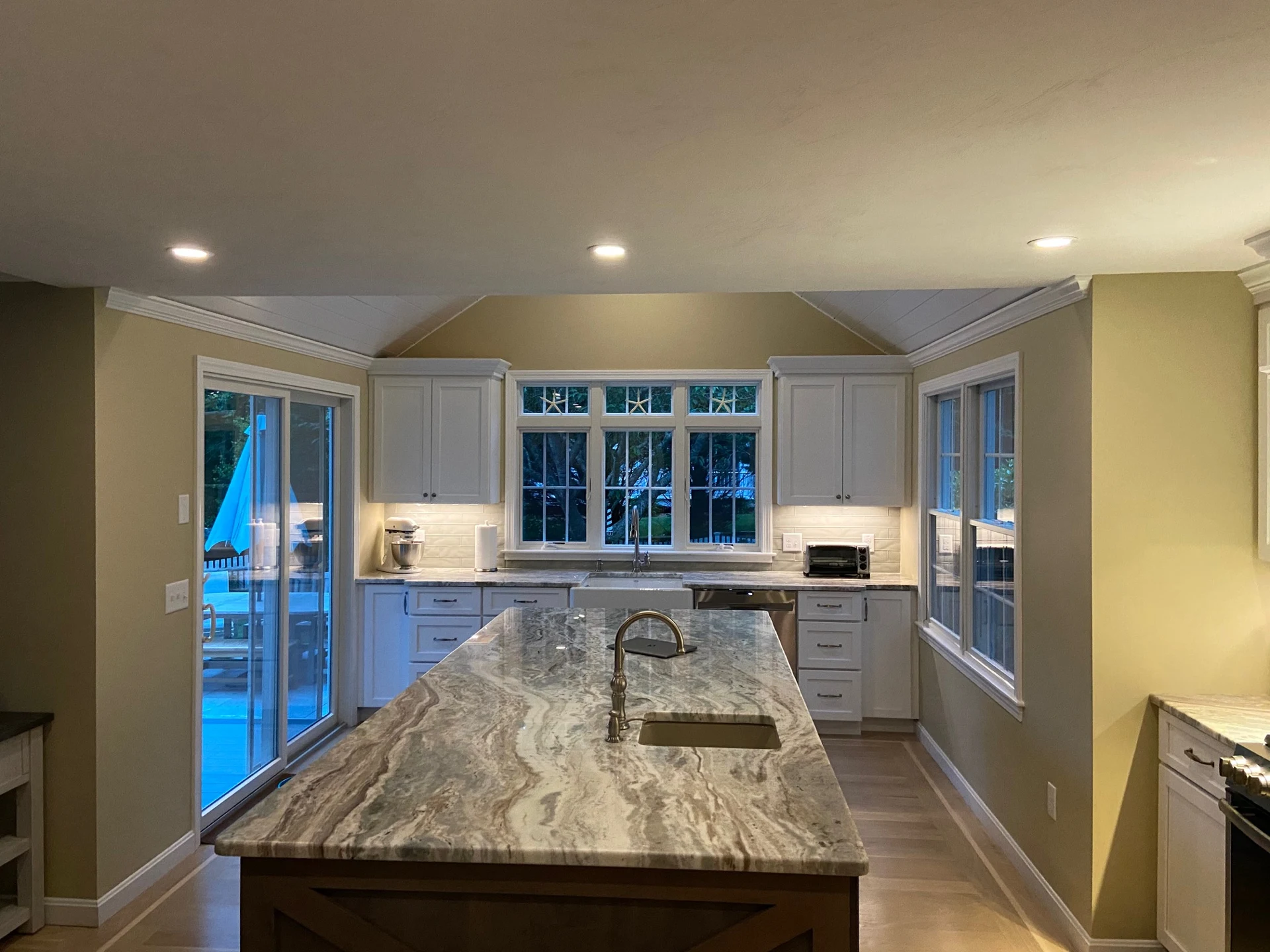 White cabinetry and granite island in a Ridge Point kitchen renovation